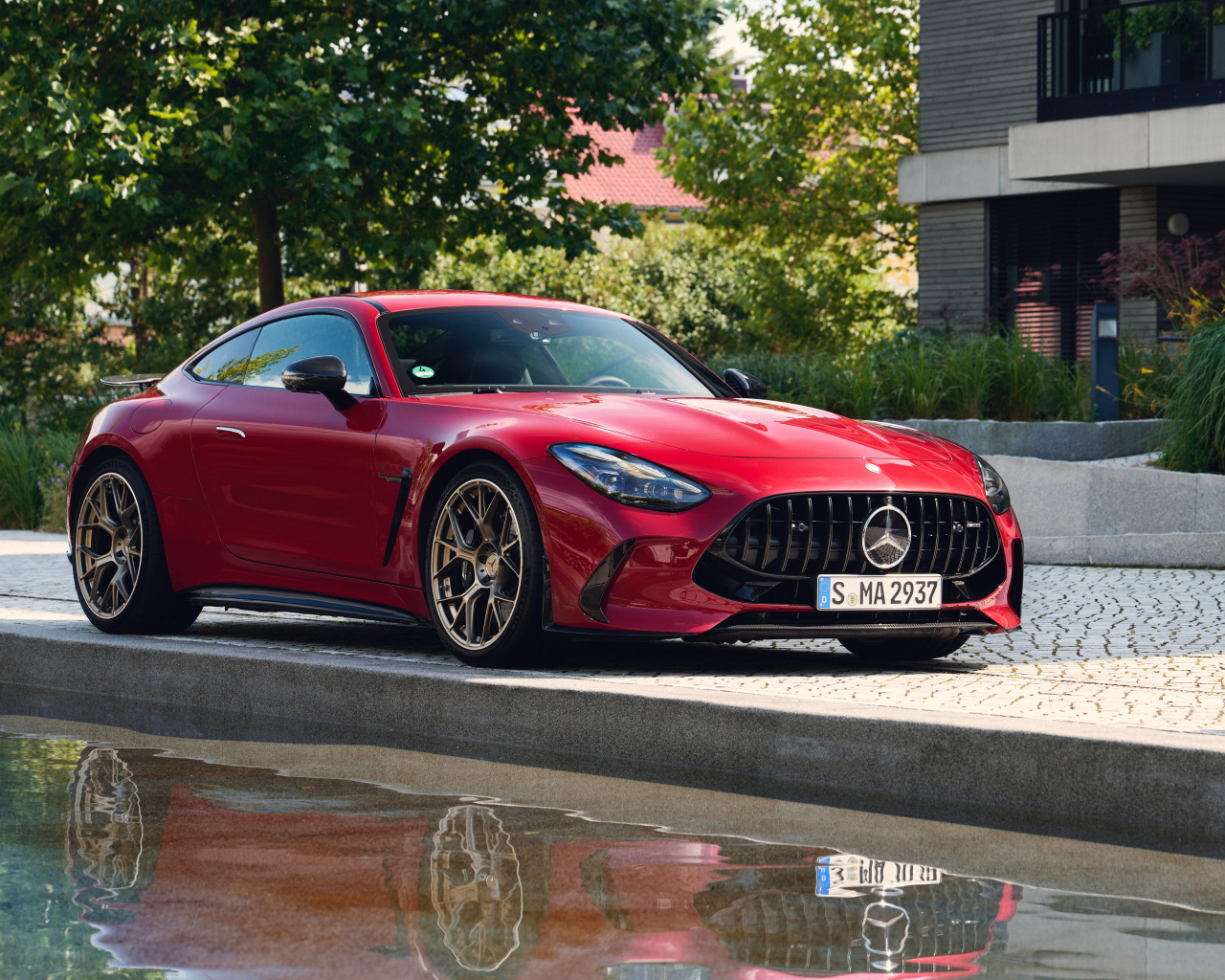 Красный автомобиль Mercedes-AMG GT 63 S E Performance 2024  года у воды