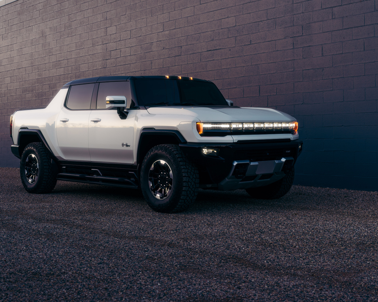 Большой стильный Hummer EV  у стены