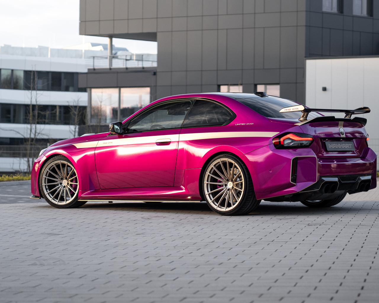 Вид сзади на розовый автомобиль Manhart MH2 GTR II 2024 года