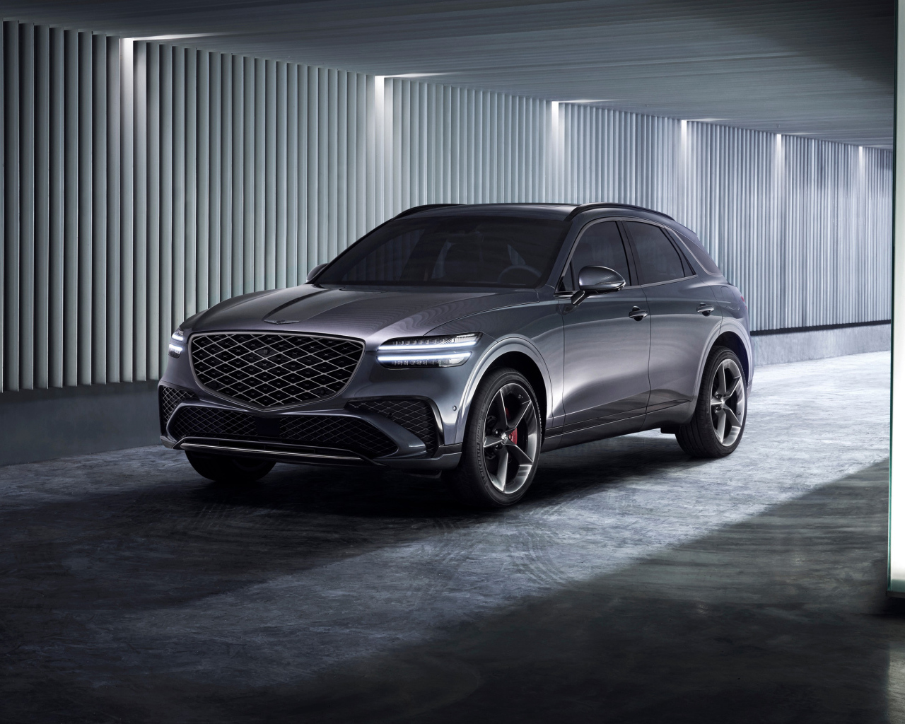 Серебристый автомобиль Genesis GV70 Sport 2024 года