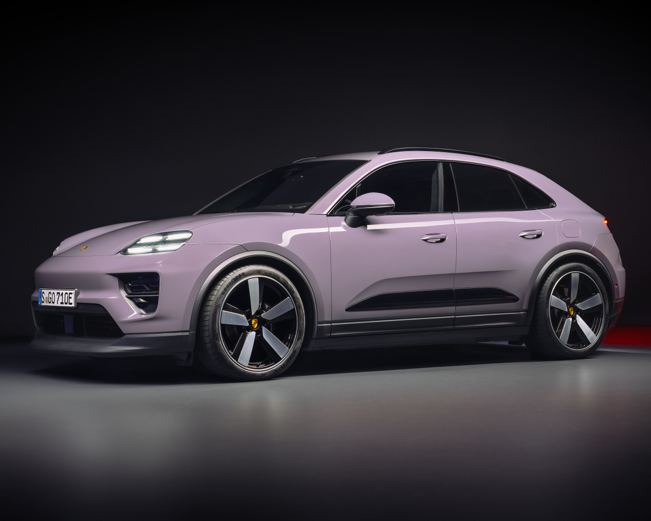 Автомобиль Porsche Macan 4 2024 года на черном фоне