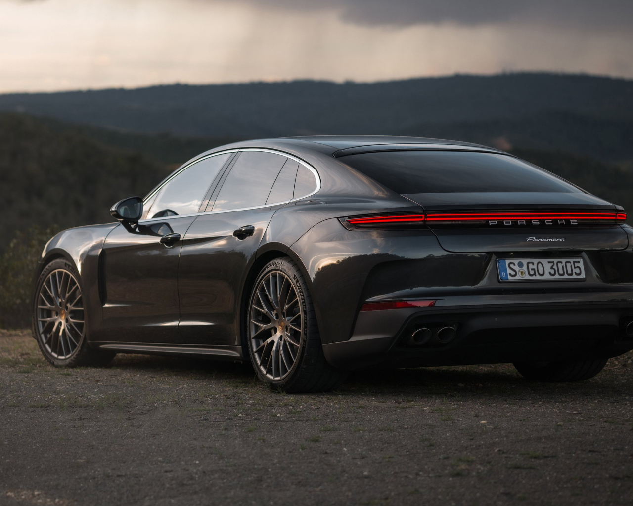 Черный автомобиль Porsche Panamera 2024 года вид сзади