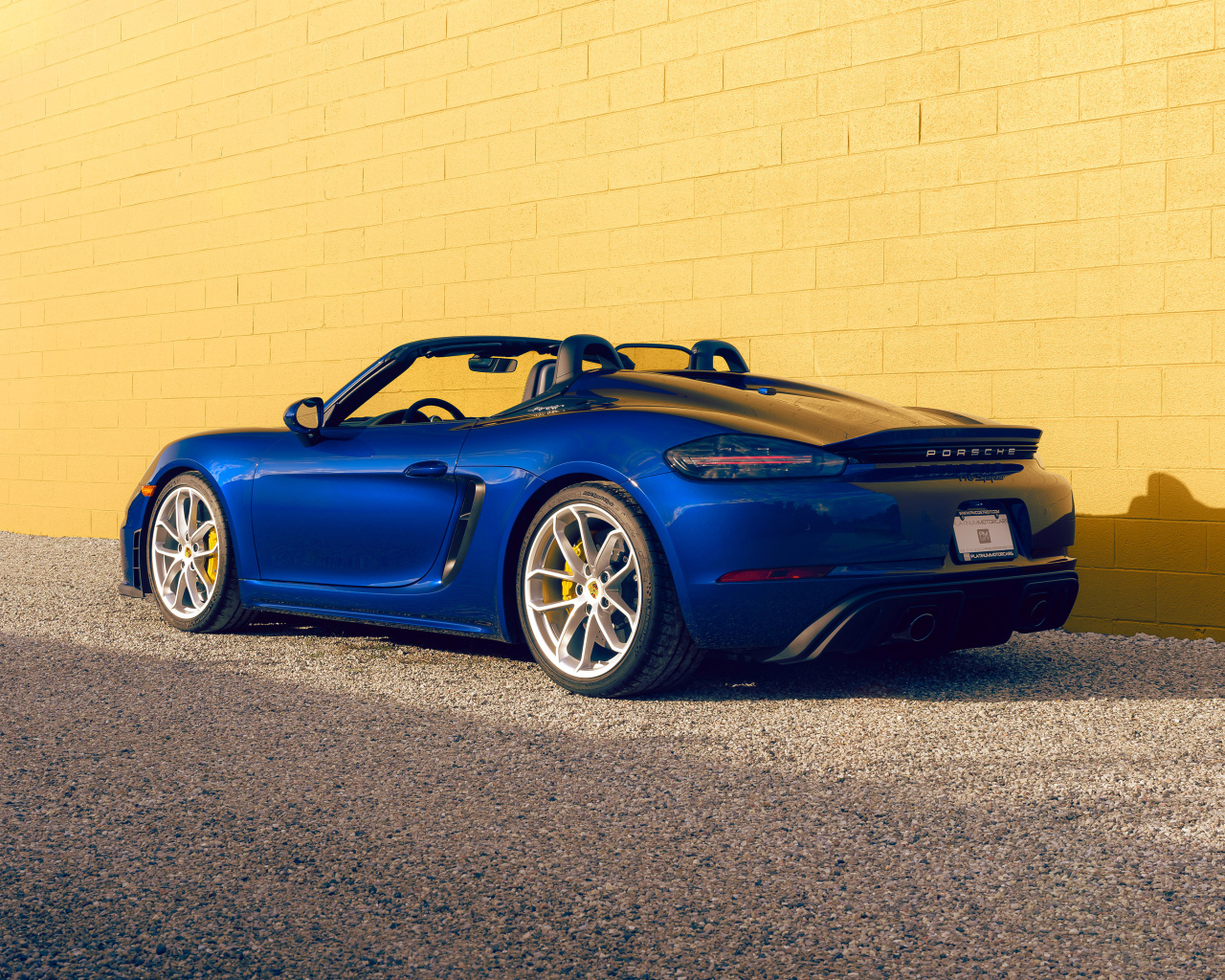 Вид сзади на синий автомобиль Porsche 718 Spyder