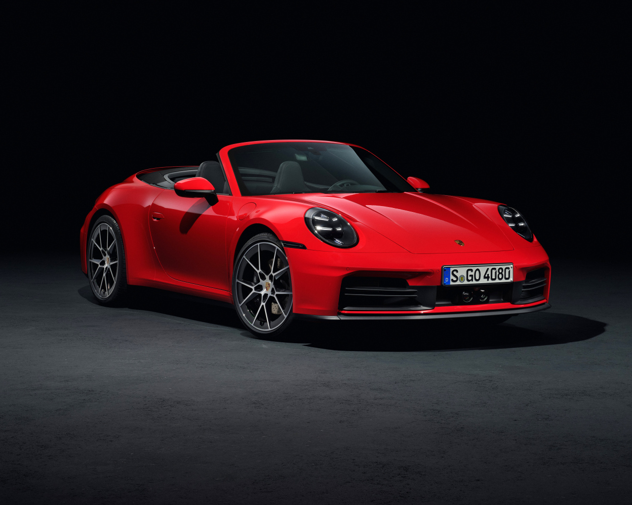 Красный автомобиль Porsche 911 Carrera Cabriolet 2024 года