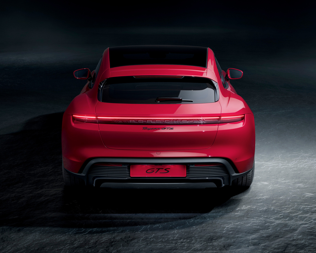Красный автомобиль Porsche Taycan GTS  вид сзади