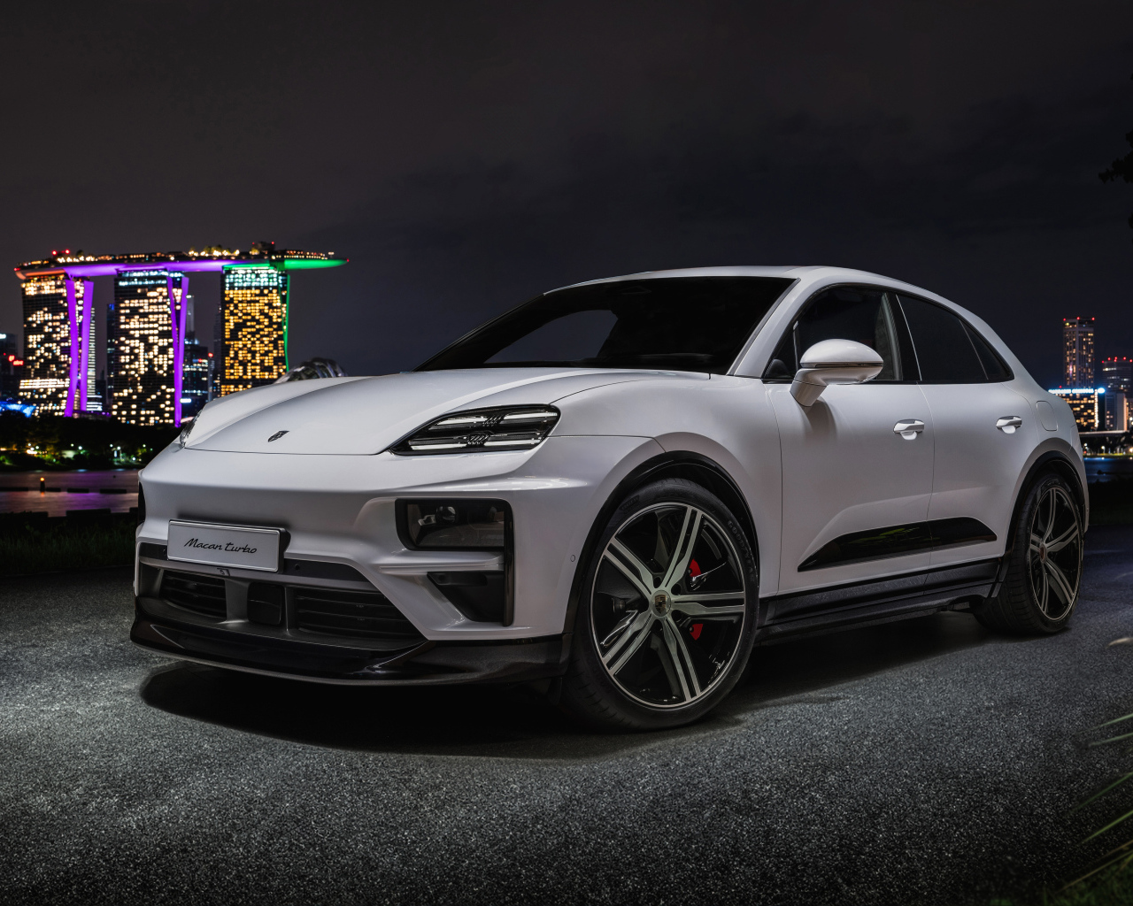 Внедорожник Porsche Macan Turbo 2024 года на фоне ночного города