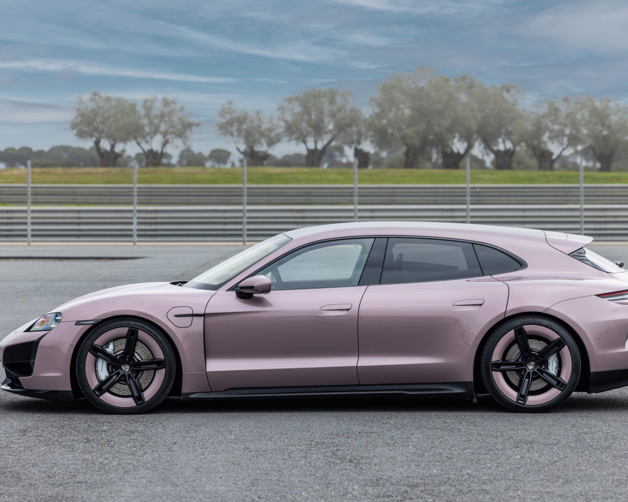 Вид сбоку на автомобиль Porsche Taycan Turbo Sport Turismo 2024 года