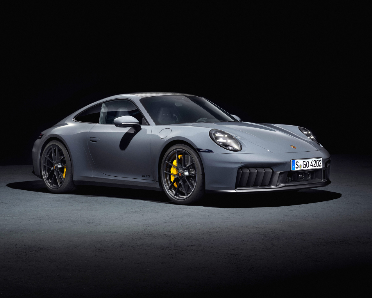 Серебристый автомобиль  Porsche 911 Carrera GTS 2024 года