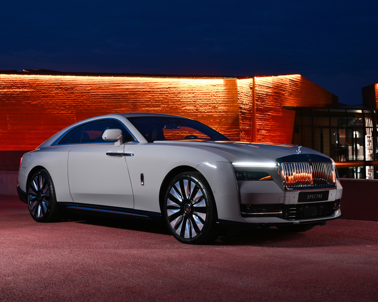 Дорогой автомобиль Rolls-Royce Spectre у здания