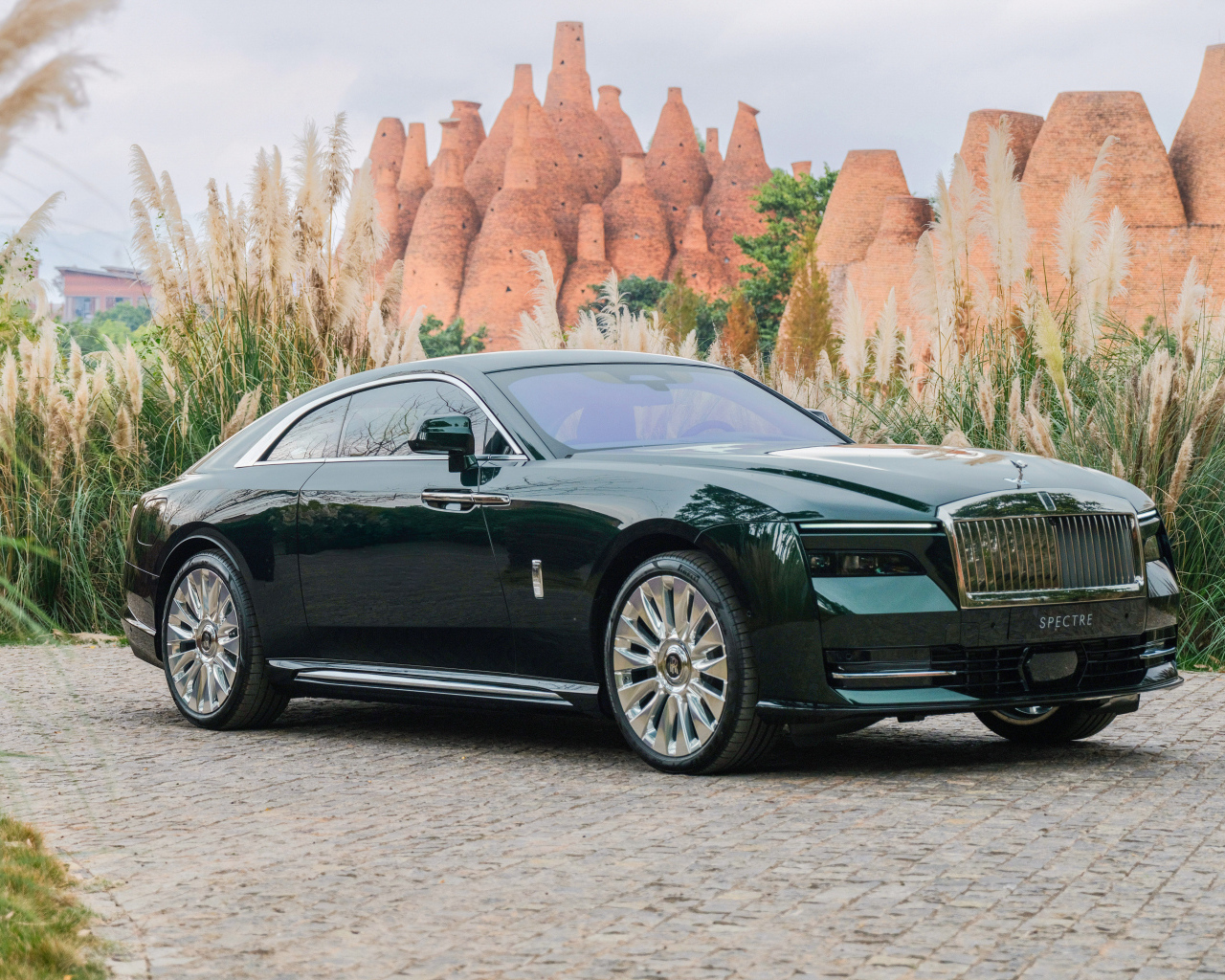 Дорогой зеленый автомобиль Rolls-Royce Spectre