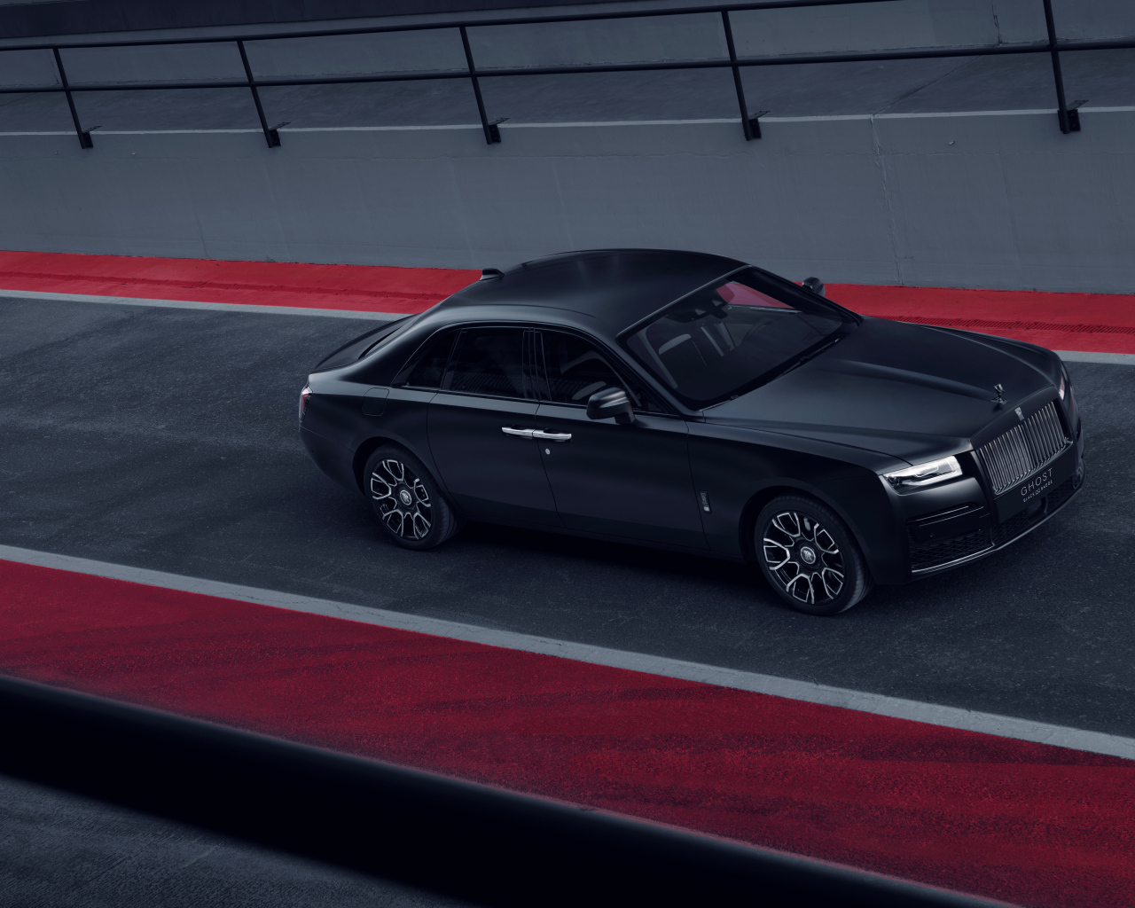 Черный автомобиль Rolls-Royce Black Badge Ghost на дороге