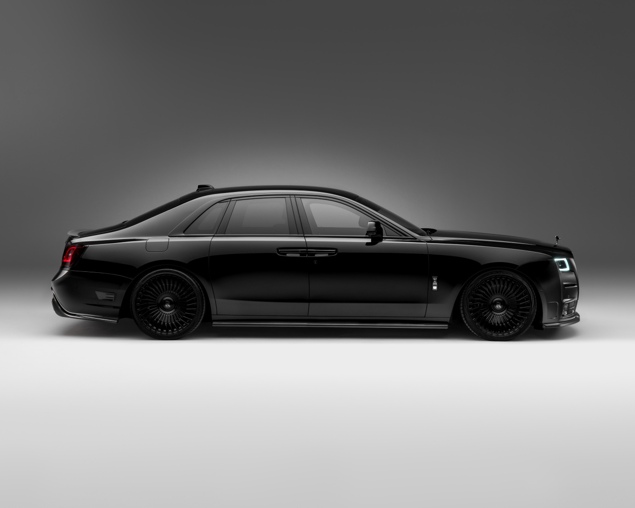 Вид сбоку на черный автомобиль Rolls-Royce Ghost