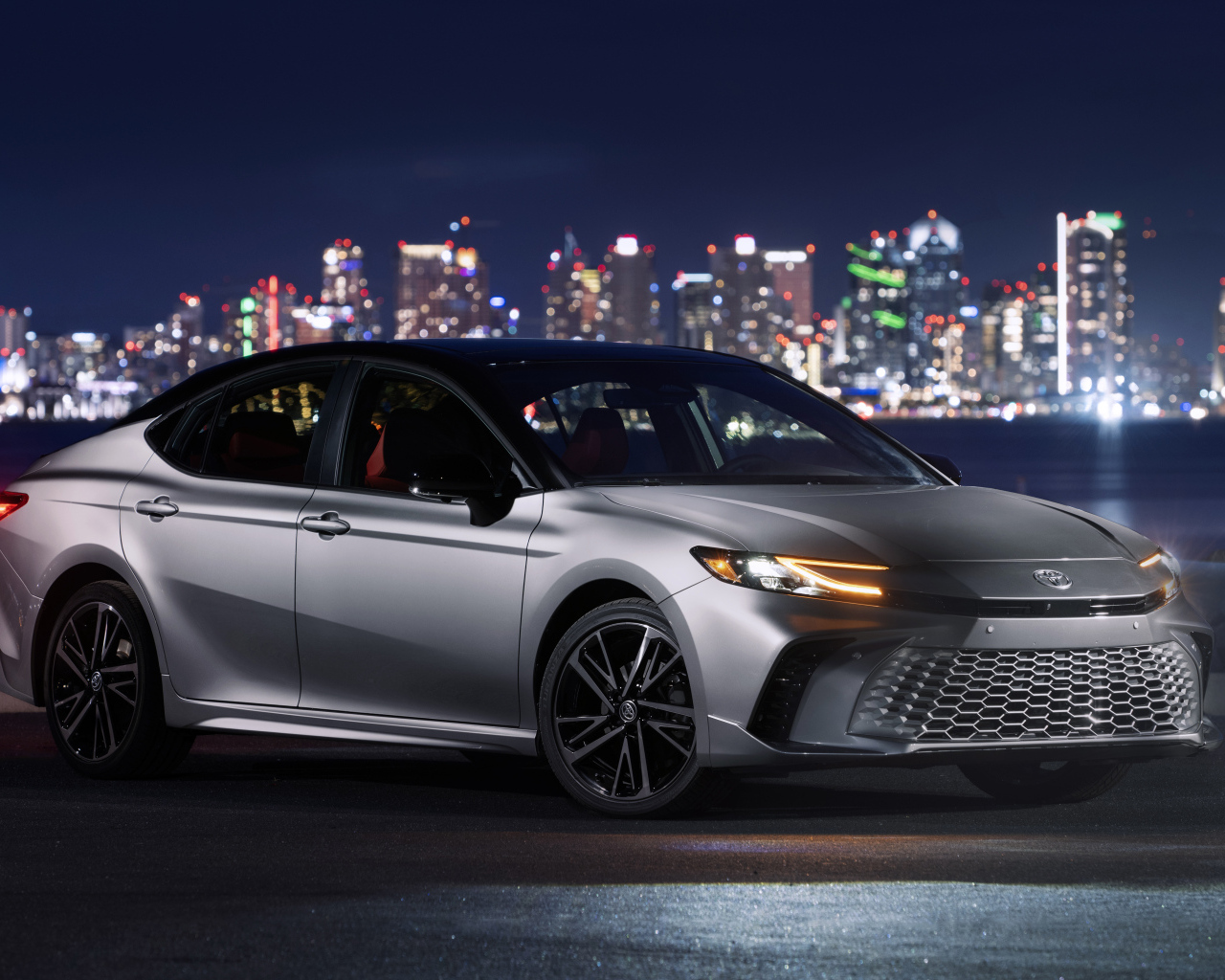 Новый автомобиль Toyota Camry XSE HEV AWD 2025 года на фоне города