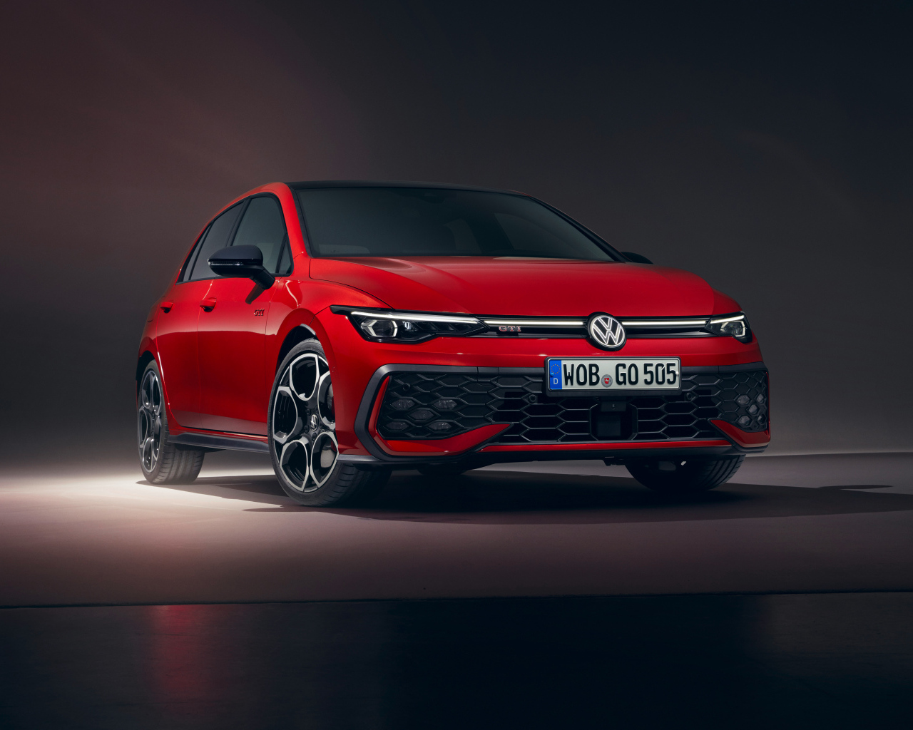 Красный автомобиль Volkswagen Golf GTI 2024 года