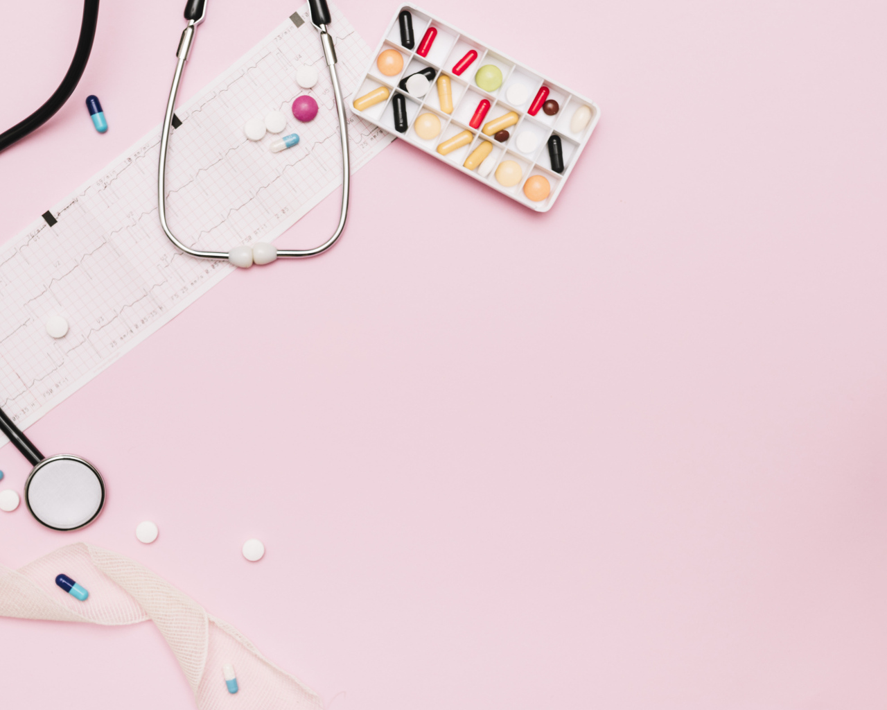 Стетоскоп и лекарства на кардиограмме на розовом фоне