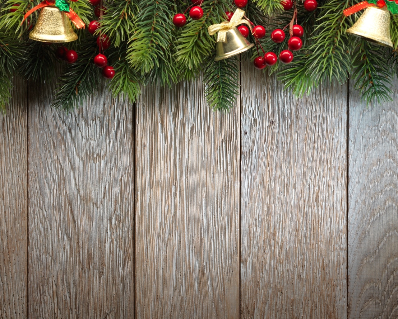 Деревянный новогодний фон с еловой веткой и колокольчиками