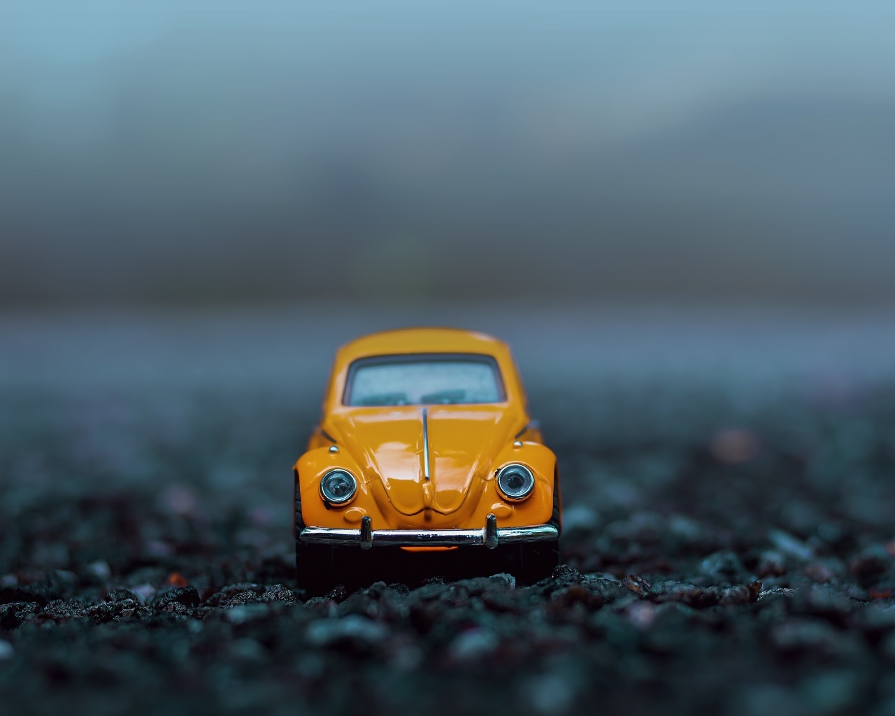 Маленькая игрушечная машинка стоит на асфальте