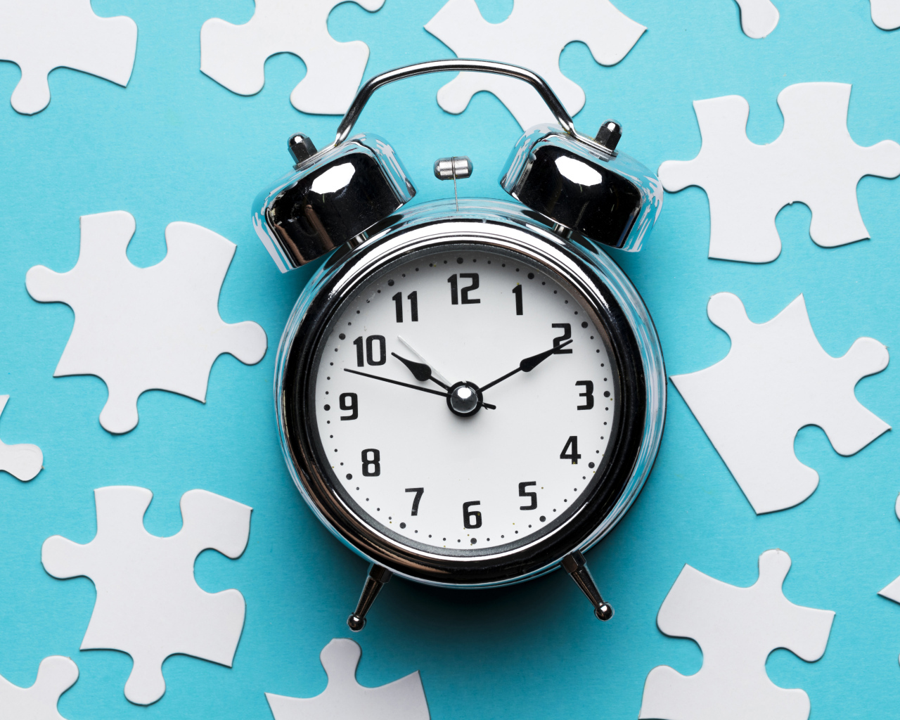 Будильник на голубом фоне с пазлами