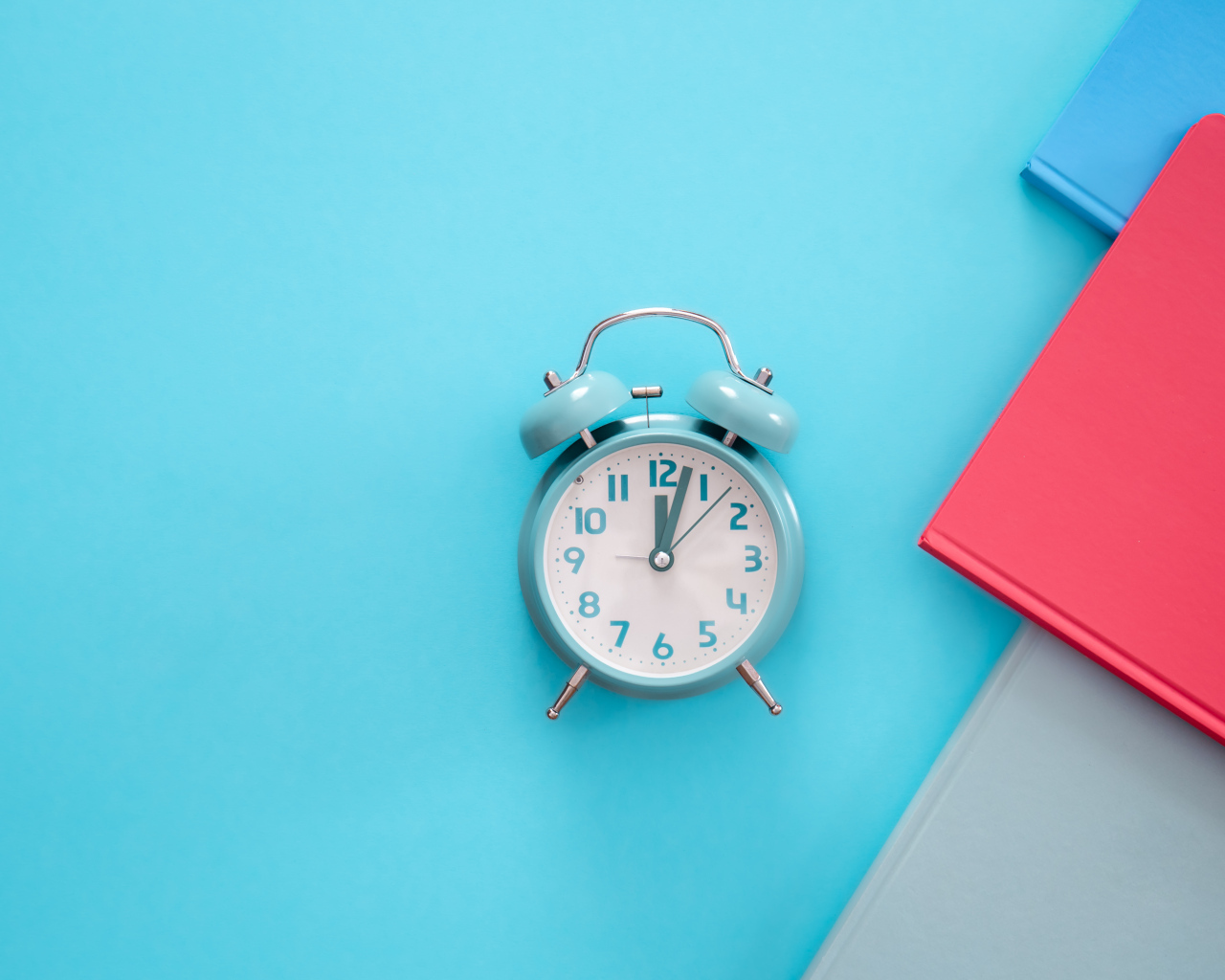 Будильник с книгами на голубом фоне