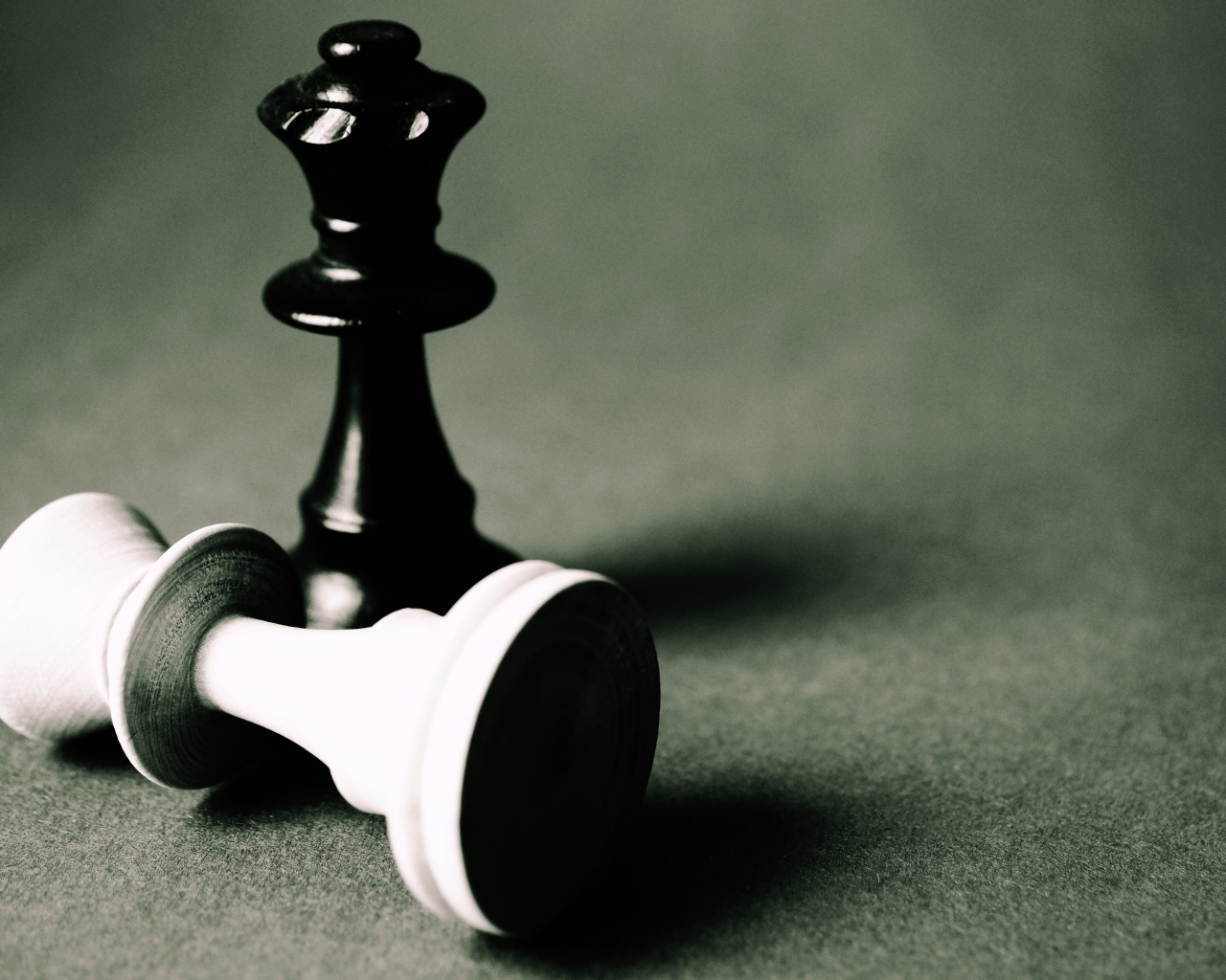 Черная и белая шахматные фигуры на сером столе