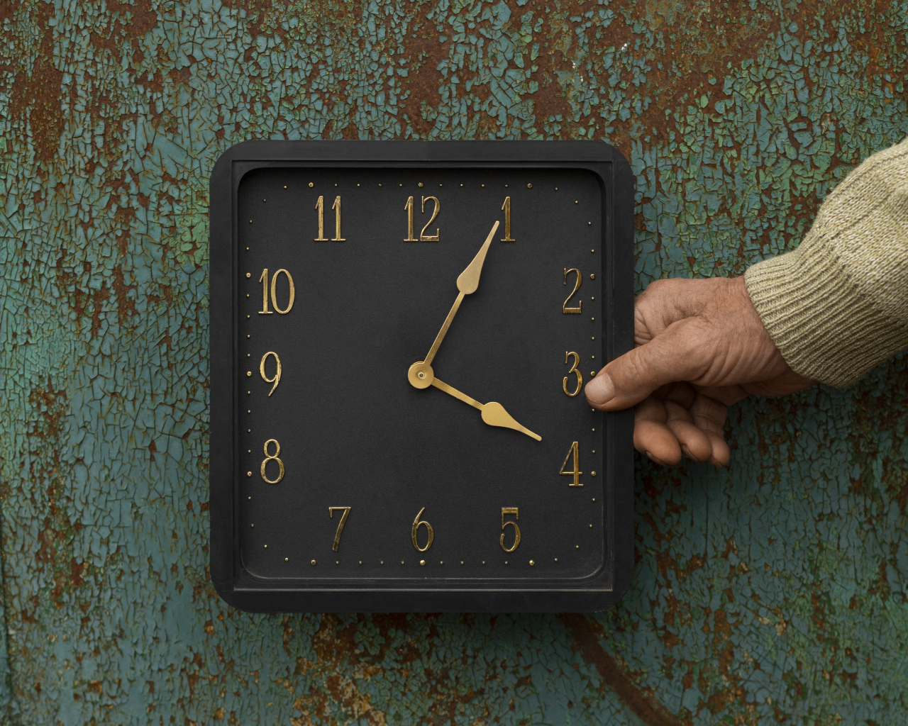 Черные квадратные часы на старой стене