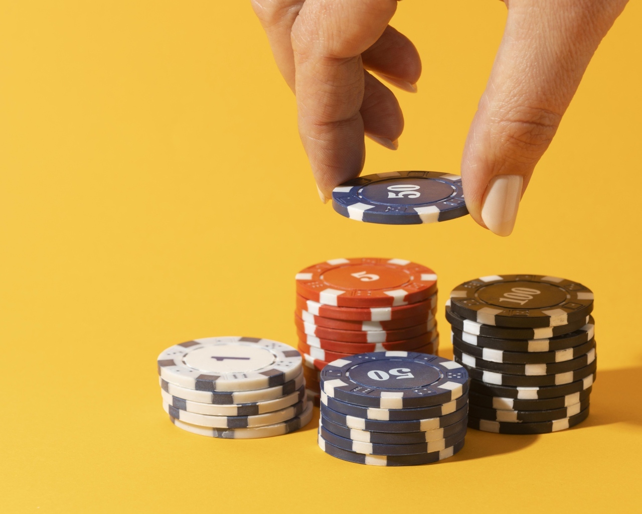 Фишки для казино с рукой на желтом фоне