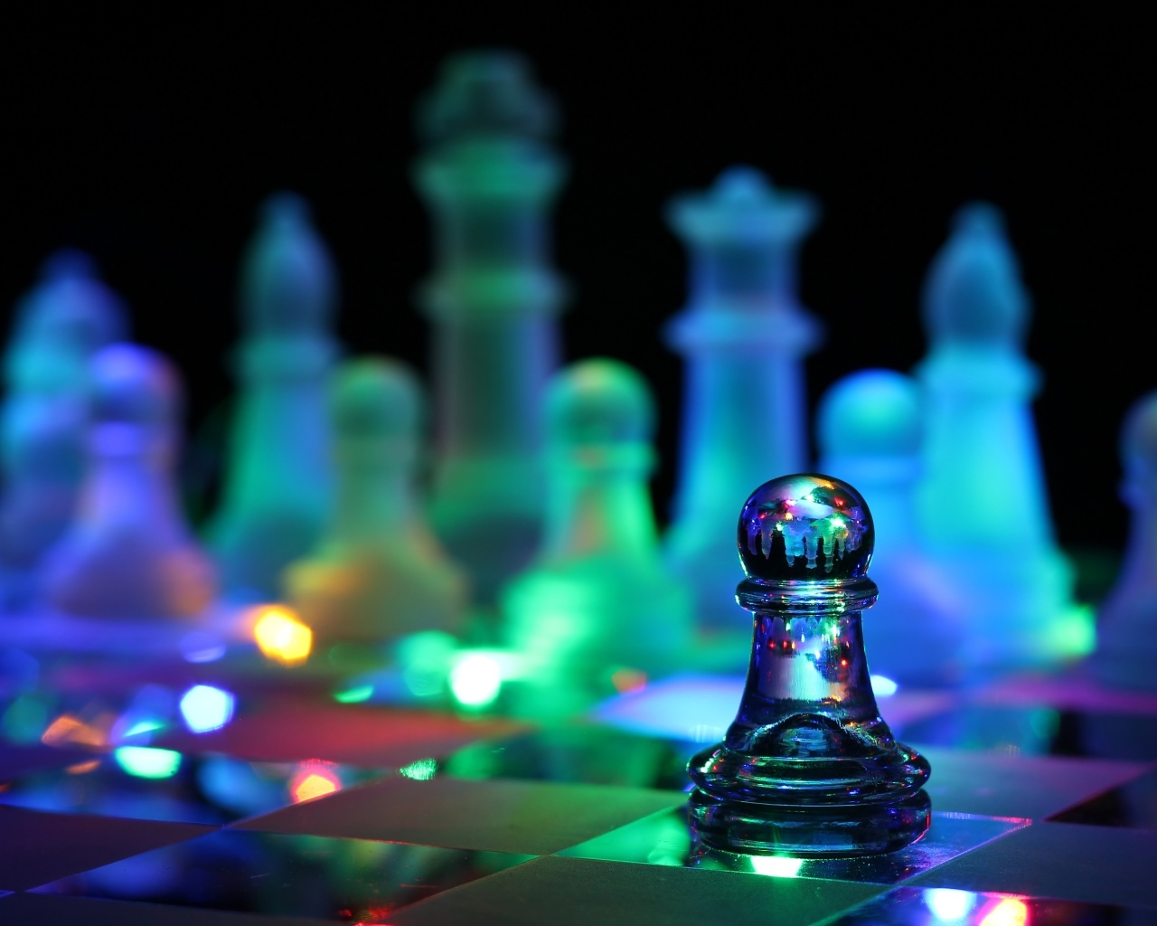 Стеклянные шахматы с гирляндой лежат на доске