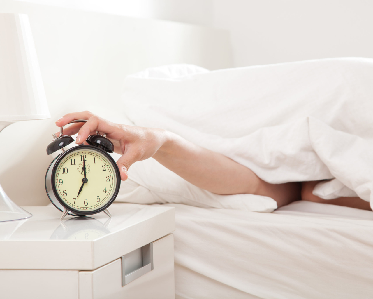 Рука под одеялом отключает будильник