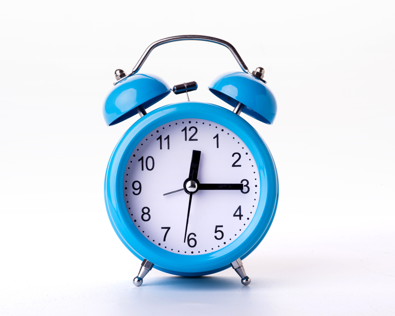 Большой голубой будильник на белом фоне