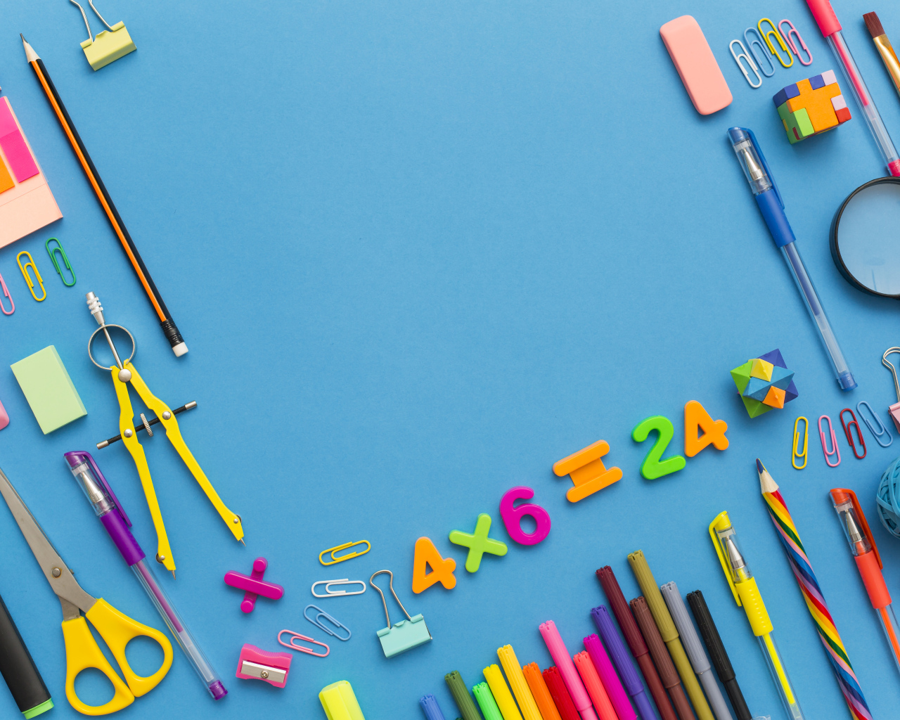 Много разных канцелярских предметов на голубом столе