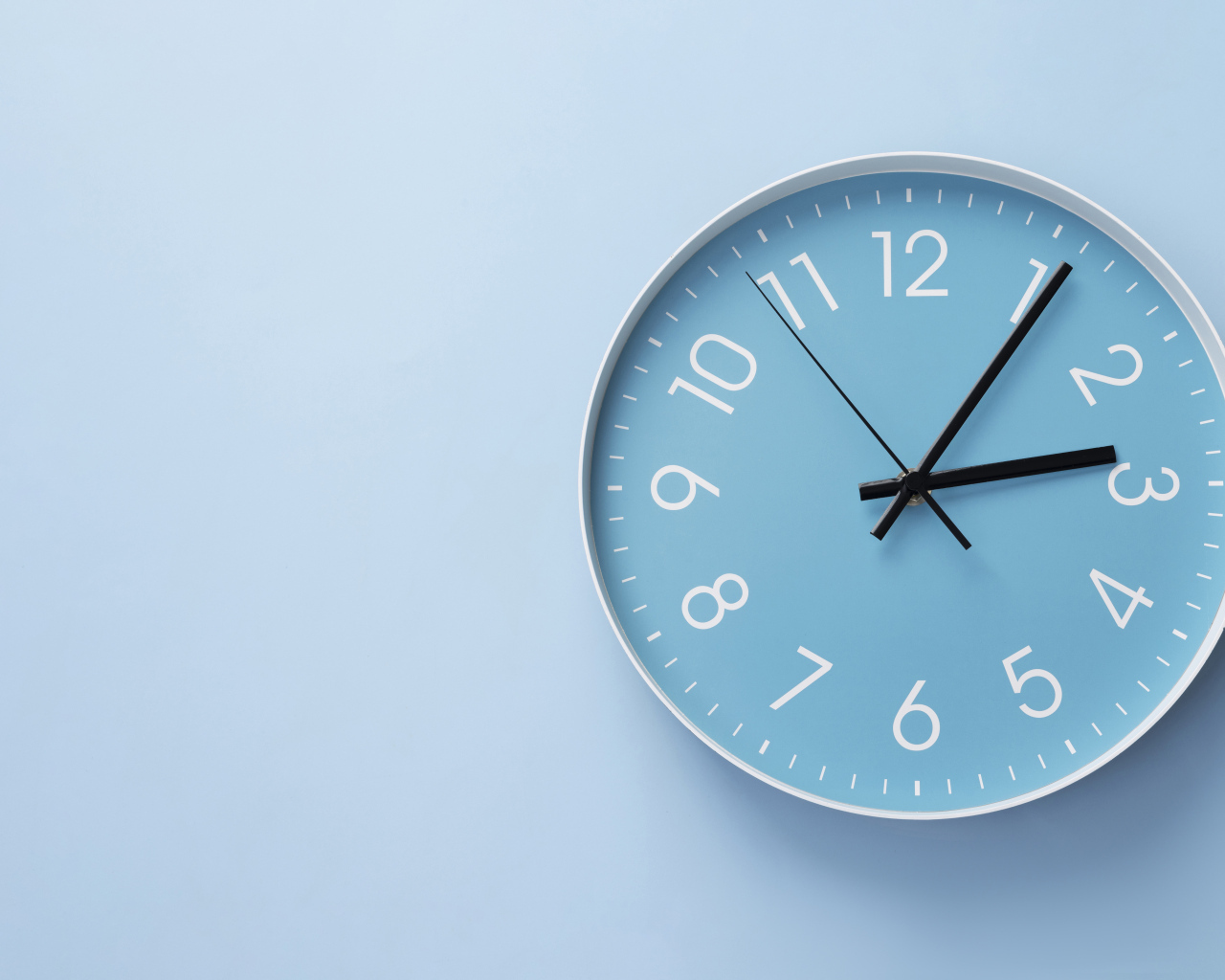 Круглые часы на голубом фоне крупным планом