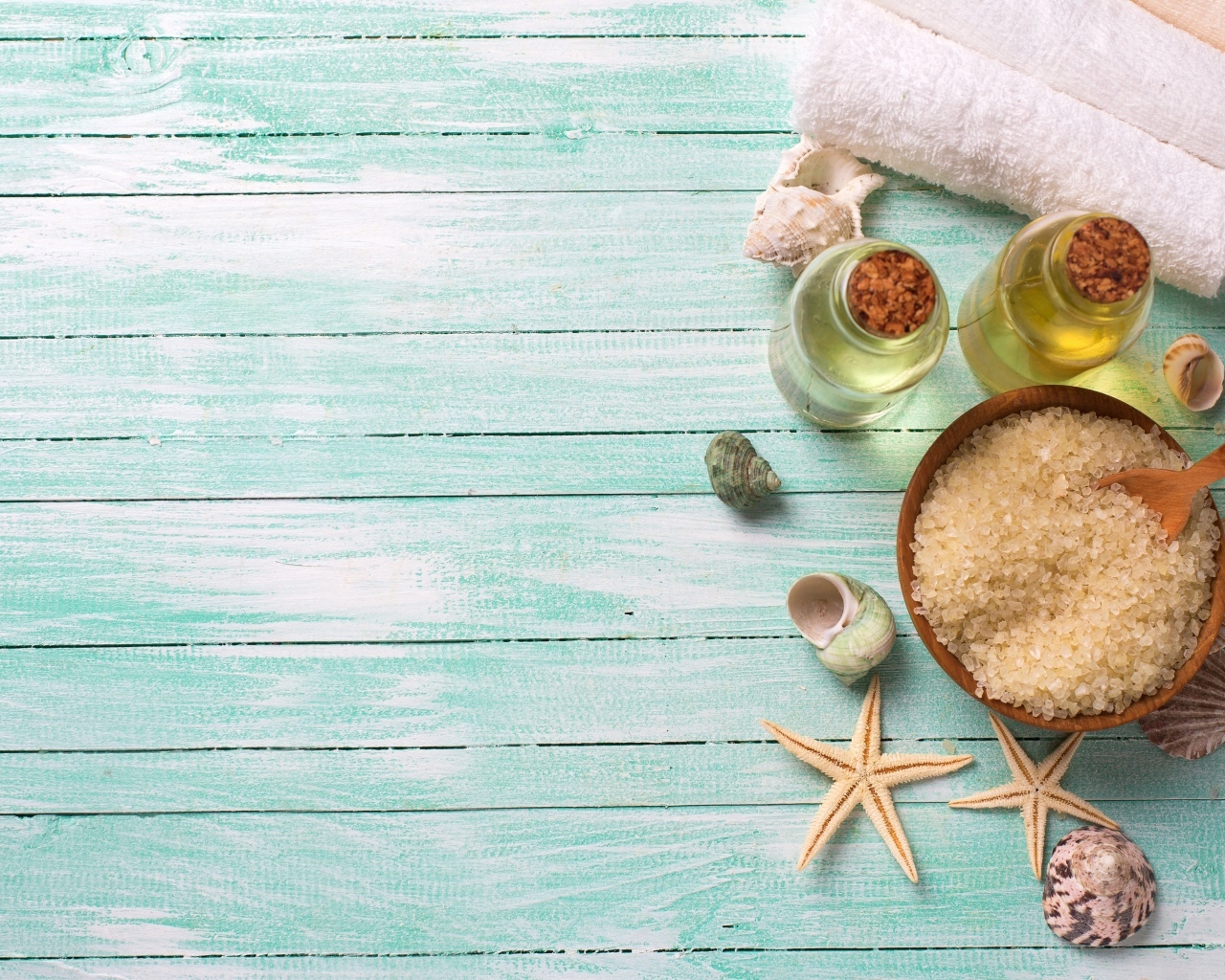 Морская соль, масло и полотенца на голубом столе