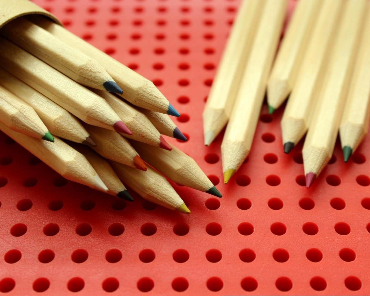 Заточенные карандаши на красном фоне