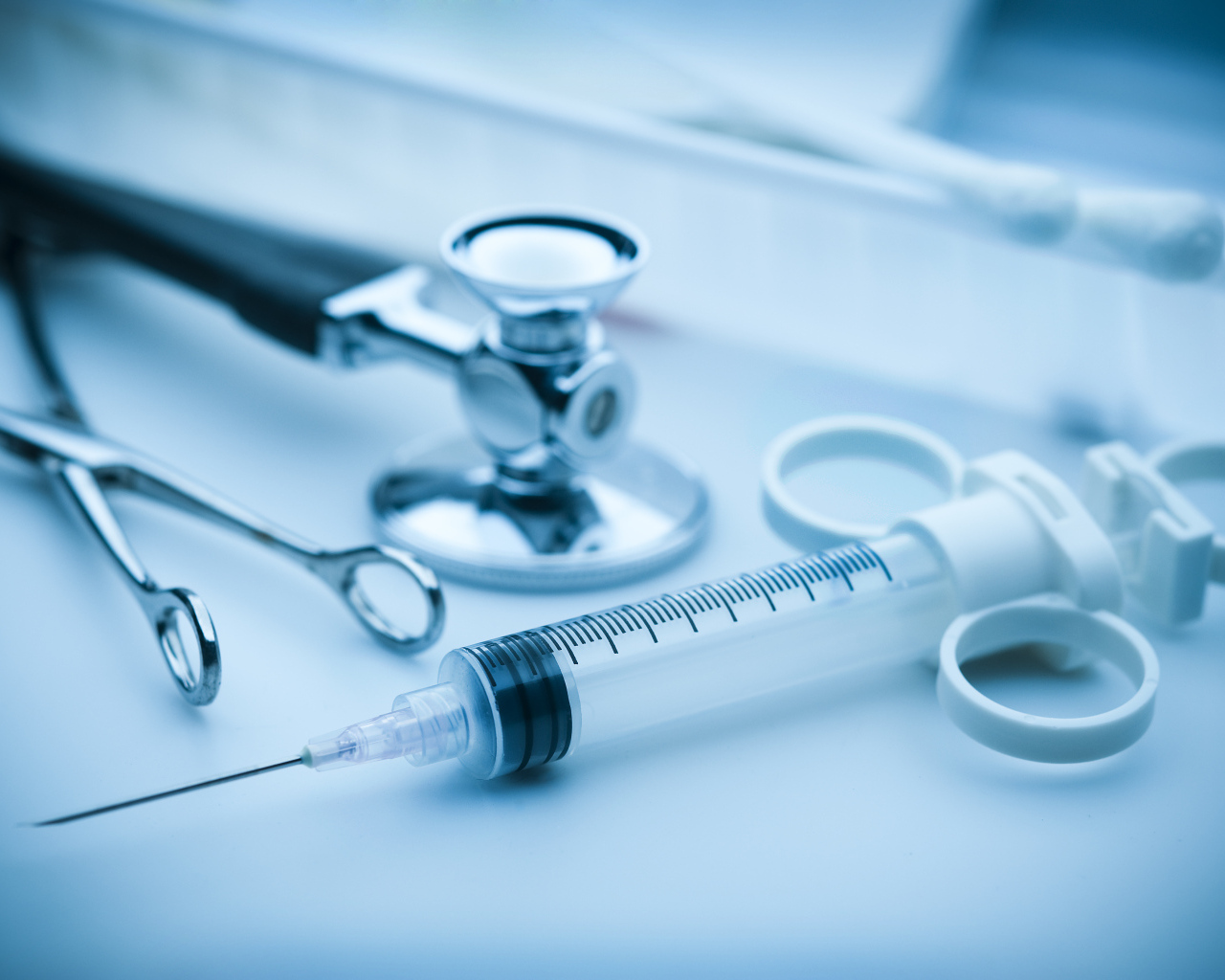 Шприц, зажим  и стетоскоп на столе