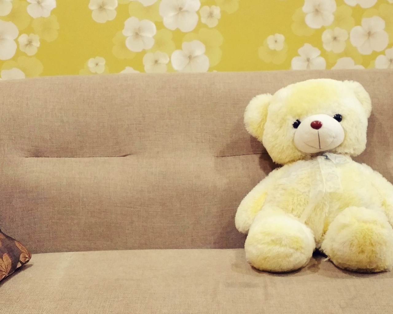 Плюшевый медведь лежит на диване