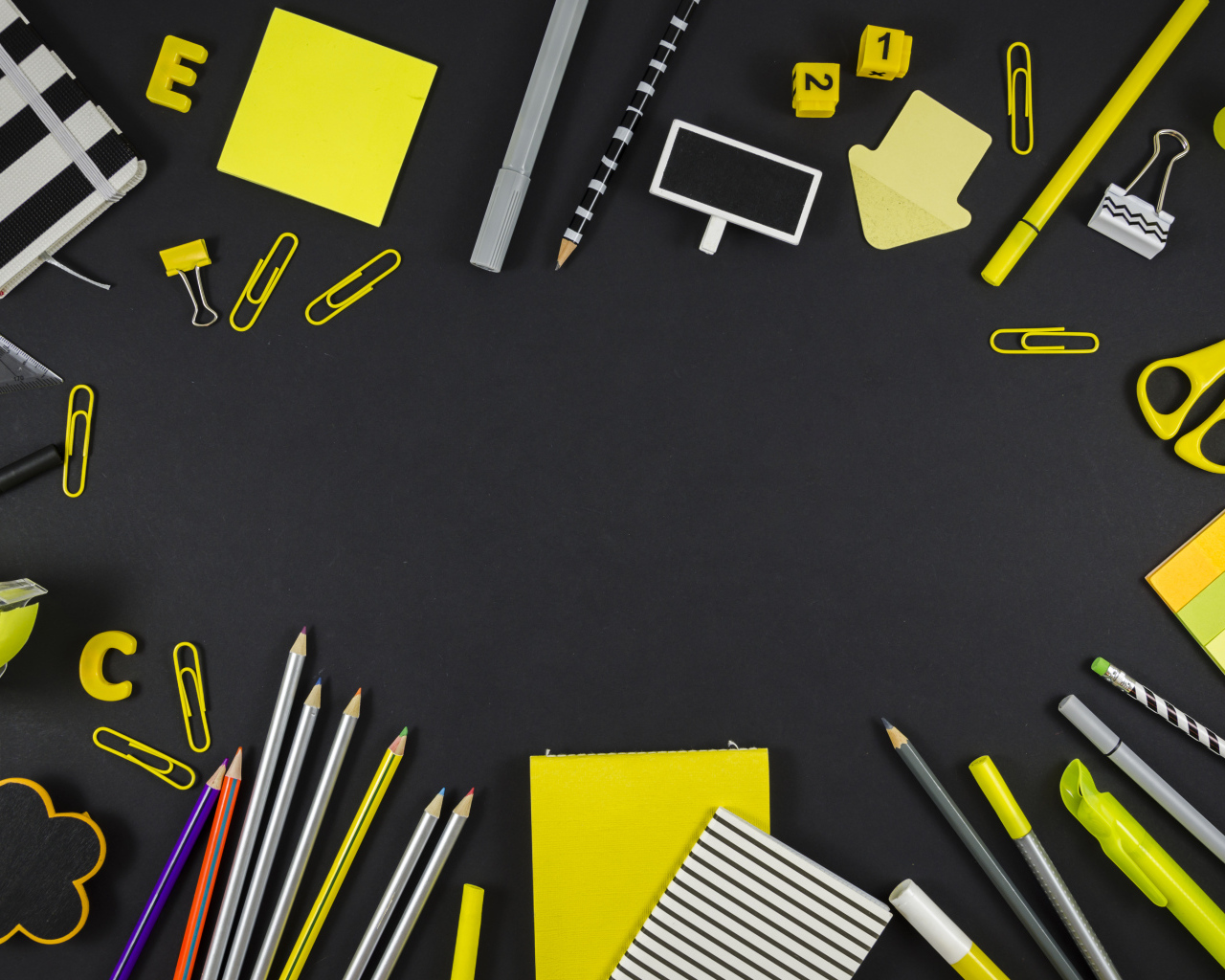 Желтые разные канцелярские предметы на черной поверхности 