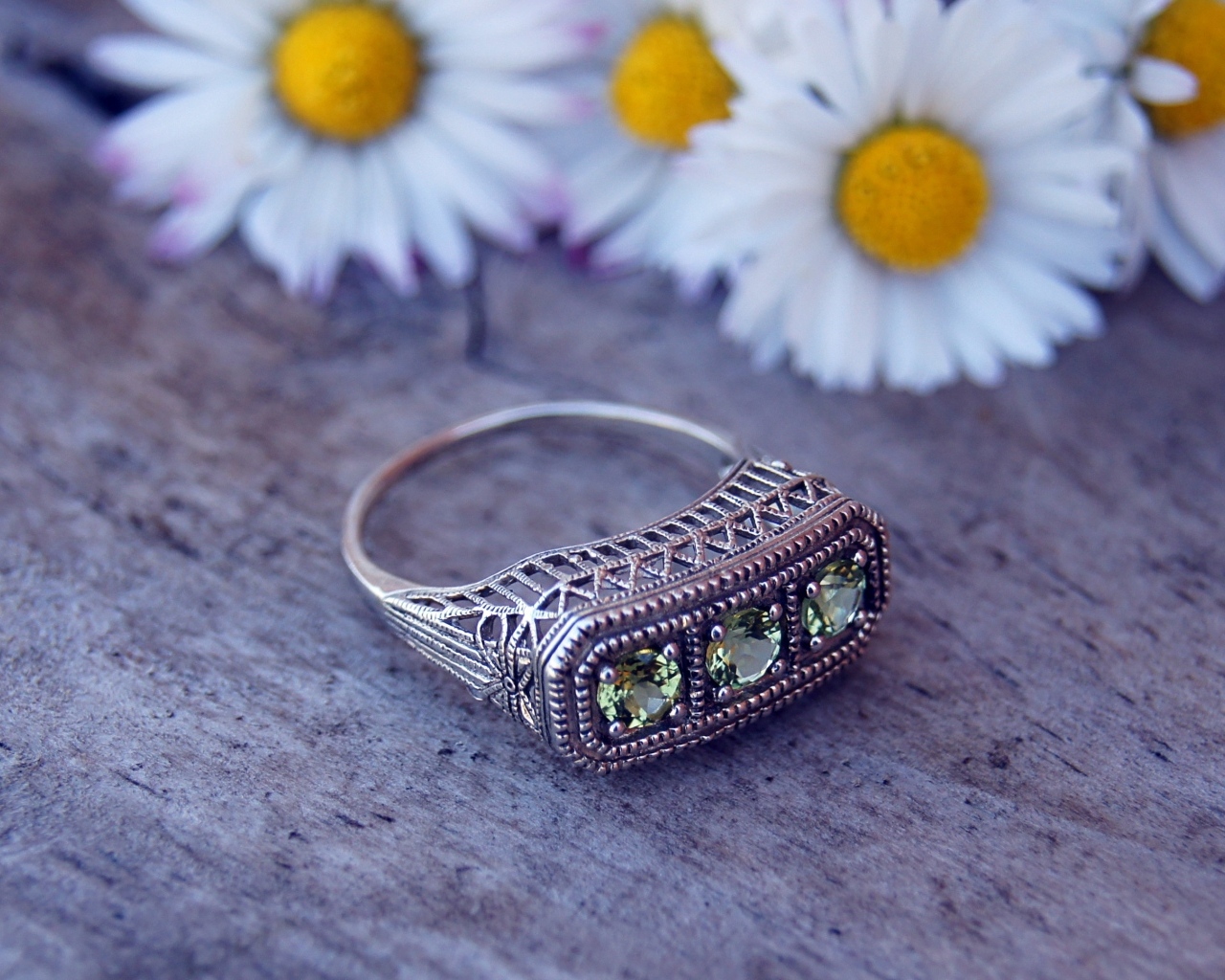 Старинный перстень на столе с ромашками