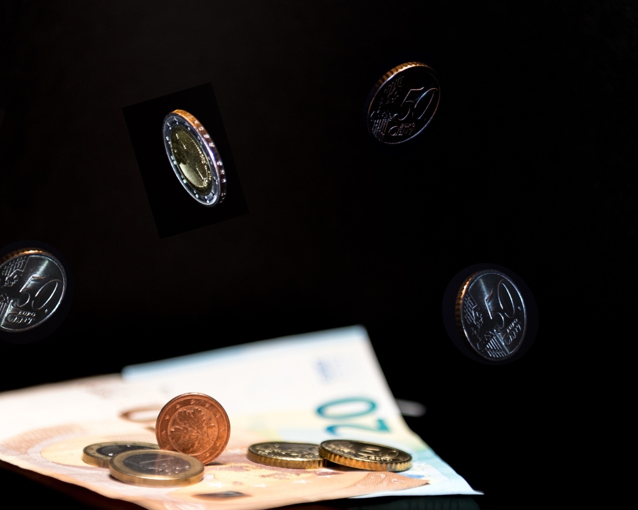 Купюры с монетами на черном фоне