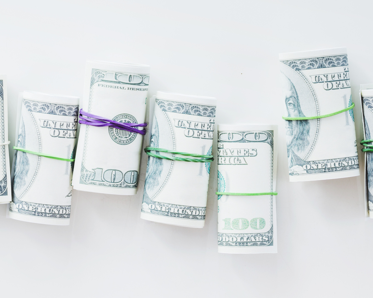 Свертки с долларами на сером фоне