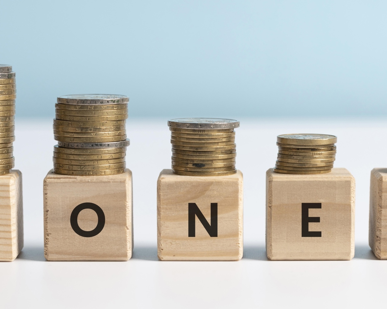 Кубики с золотыми монетами на голубом фоне