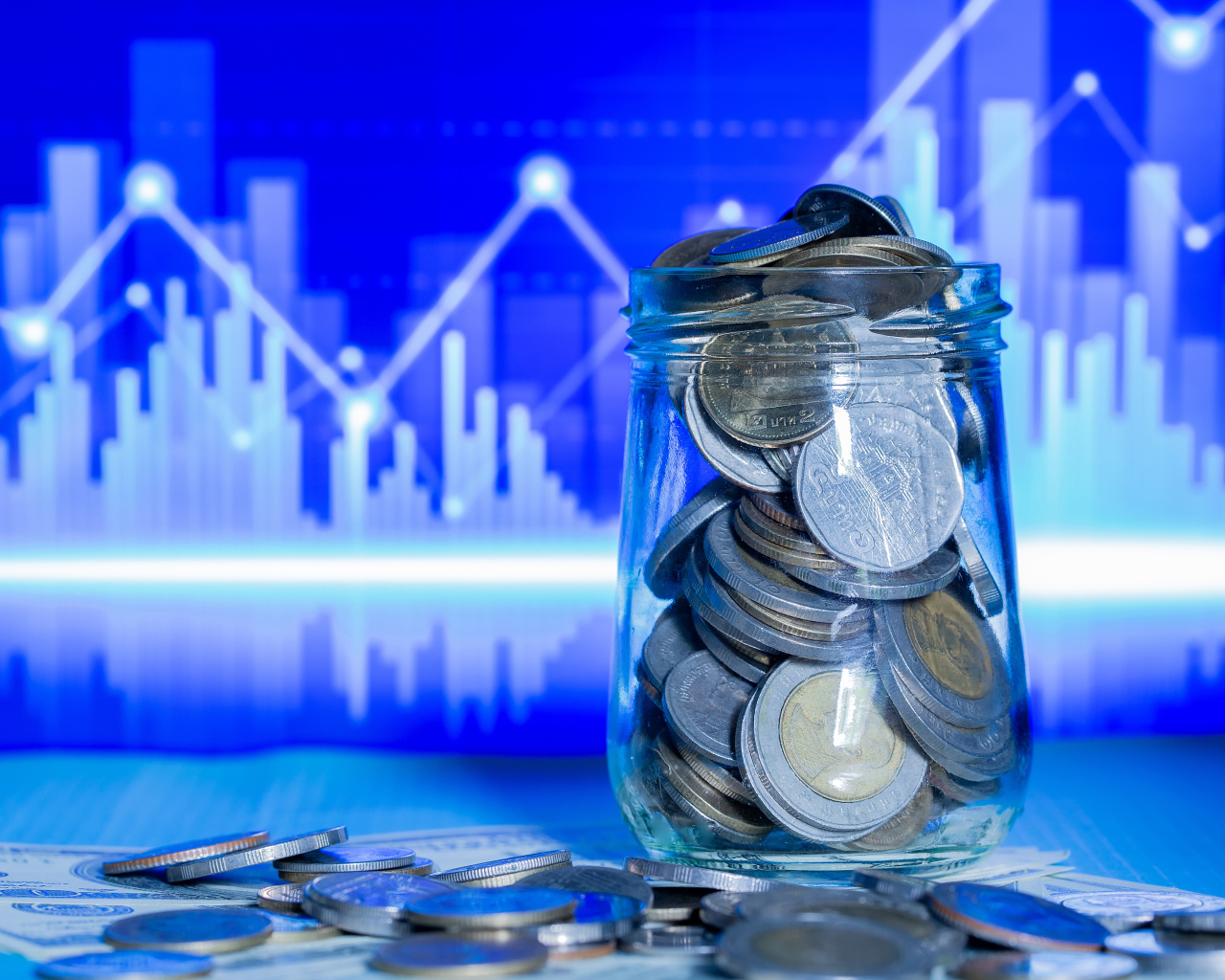 Банка с монетами на фоне таблицы