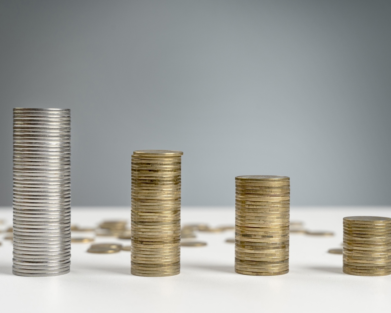 Стопки монет на сером фоне на столе