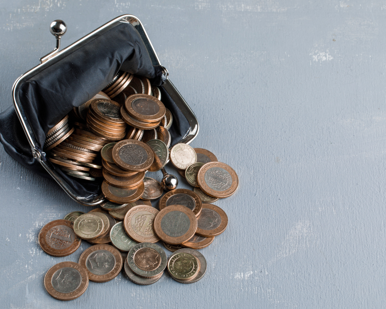 Кошелек с монетами на сером столе