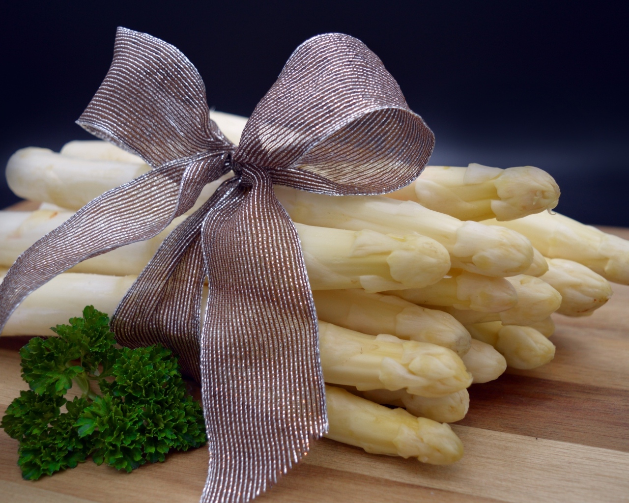 Спаржа с бантом на столе с петрушкой