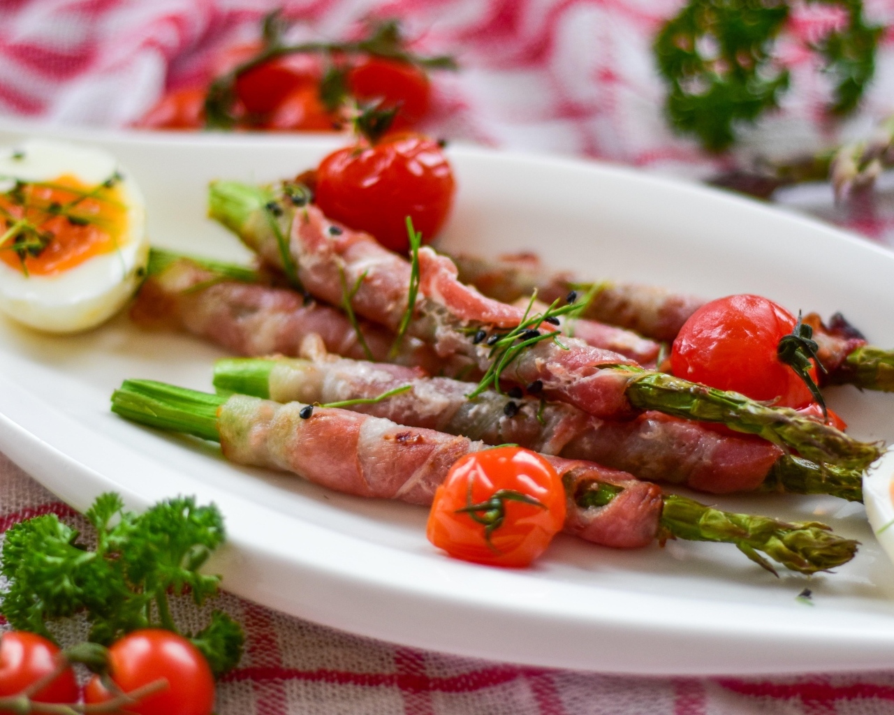 Спаржа в беконе на тарелке с вареными яйцами