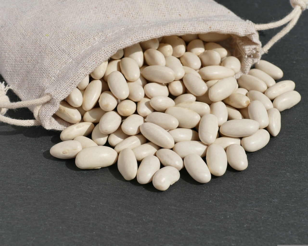 Фасоль в мешочке на сером столе