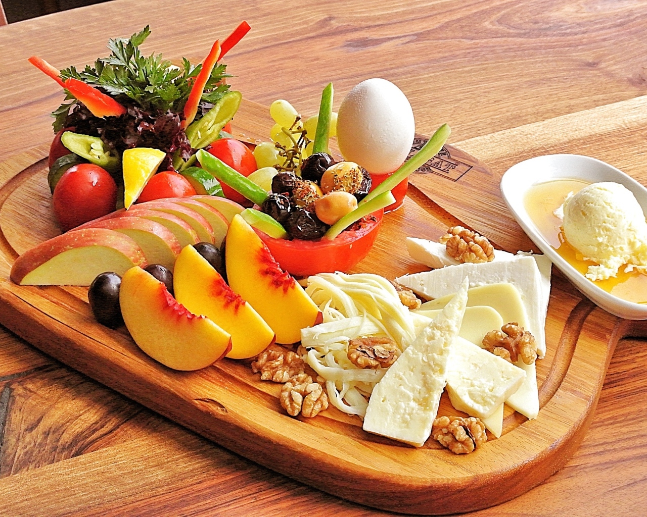 Сыр на доске с фруктами и салатом