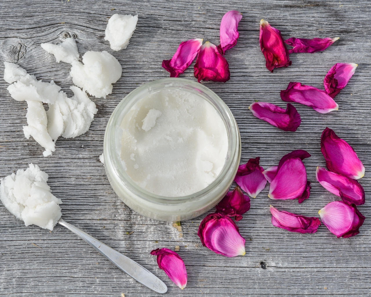 Кокосовое масло с лепестками розы на сером столе
