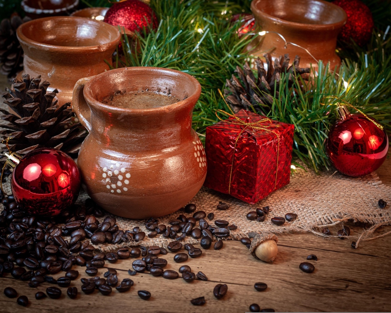 Кофейные зерна на столе с посудой и еловой веткой