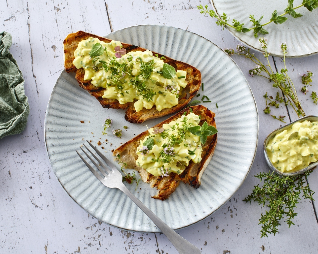 Гренки с кремом и зеленью на тарелке